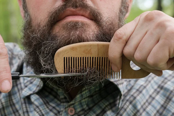 Человек с ножницами отрезал большую бороду — стоковое фото