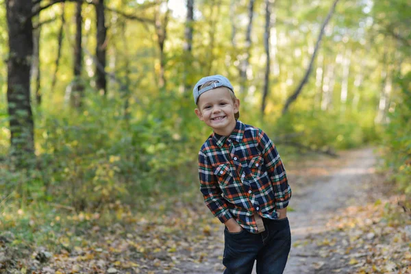 Menino feliz na floresta de outono — Fotografia de Stock