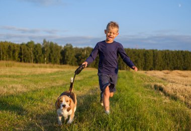Avrupa çocuk bir Beagle ile bir yürüyüş üzerinde çalışan