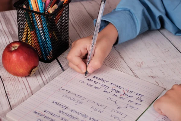 Рука школьника, пишущего слова и буквы в тетради — стоковое фото