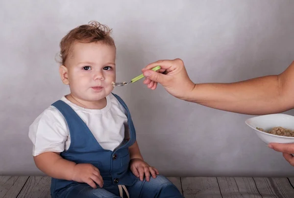 Ребенок европейский внешний вид ест кашу с ложки — стоковое фото