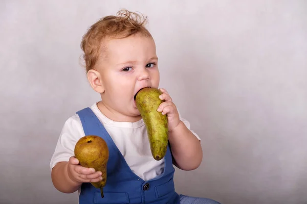 Европейский мальчик в возрасте одного года ест груши — стоковое фото