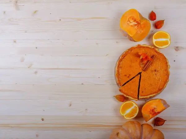 Torta de abóbora americana, abóbora, laranja, physalis em uma tábua de madeira — Fotografia de Stock