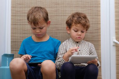 İki kardeş, yaş 4 ve 7 smartphone ve tablet üzerinde oyun