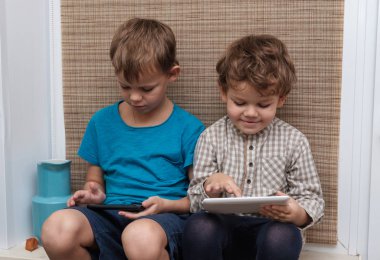 İki kardeş, yaş 4 ve 7 smartphone ve tablet üzerinde oyun