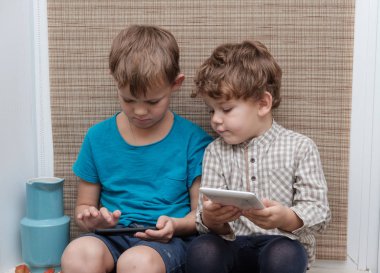 İki kardeş, yaş 4 ve 7 smartphone ve tablet üzerinde oyun