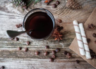 Tahta masada, cam bardakta sade kahve.