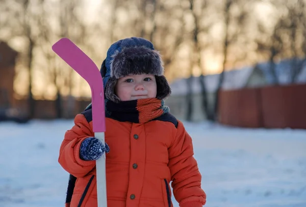 Mały chłopiec z kija hokejowego na spacer zimą — Zdjęcie stockowe