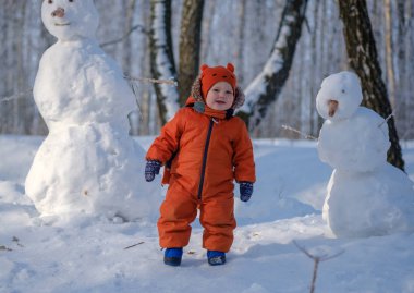 Avrupa çocuk ve karlı bir ormandaki kardan adam