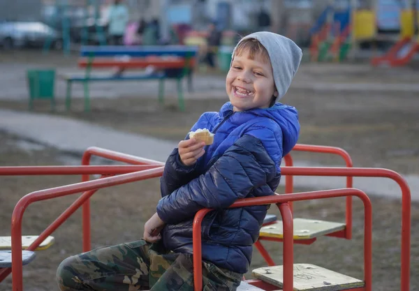Европейский мальчик ест мороженое и смеется — стоковое фото
