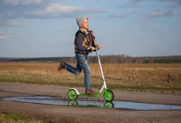 Avrupa çocuk onun scooter su birikintileri üzerinden sürmek