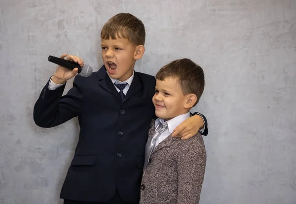 Dois meninos bonitos jogar com microfone vocal copiando cantores populares — Fotografia de Stock