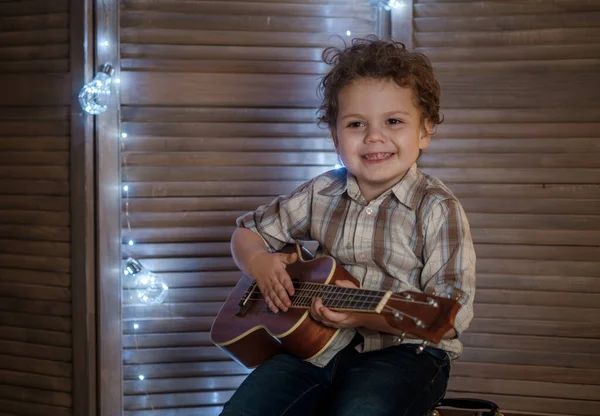 Menino Bonito Com Uma Guitarra Ukulele Suas Mãos Aprender Tocar — Fotografia de Stock