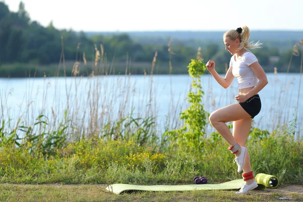 Молода красива жінка біжить показує прес тренування в шлунку носить топ . — стокове фото