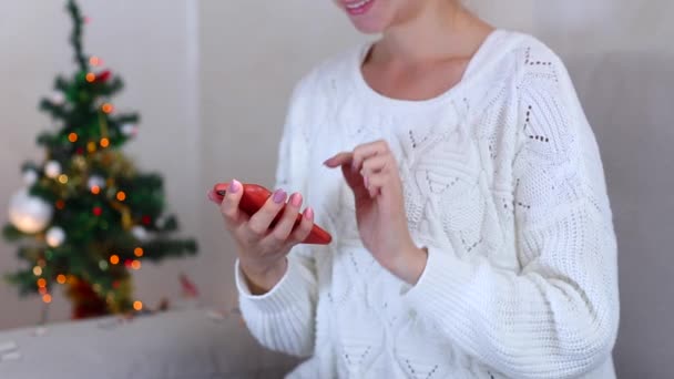 Menina usa mão pressiona tela do telefone no Bokeh Xmas Eve Lights Ano Novo Árvore Confetti Natal — Vídeo de Stock