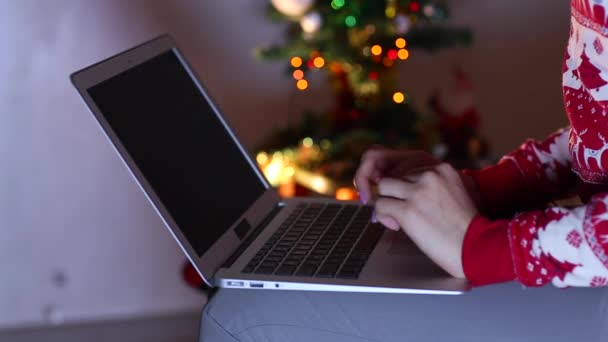 In de avond, vrouw hand Press Touch op laptop toetsenbord, lichten bokeh achtergrond van kerstboom. — Stockvideo