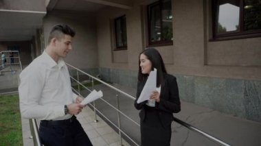 Young Beautiful Asian Business Woman Female and Caucasian Male Explain Look at Documents Talk on Office Building Stairs