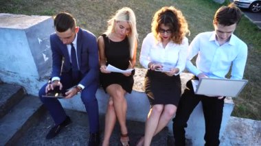 İş Ekibi Güneşe Karşı Belgeler, Dizüstü Bilgisayar, Tablet Teknolojisi ile Merkez Ofis yakınında oturuyor