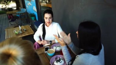 Üç güzel kadın gülümseme Cafe içinde konuşma, sırları, söyle yemek, kahve iç.