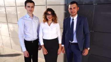 Portre iş takım ayakta yakınındaki merkezi ofis bakıyor kamera başparmak gibi