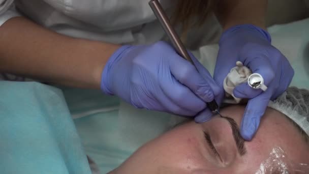 Αισθητικός κάνει διαδικασία ασθενής αντλεί τα φρύδια Mikrobleyding πελάτη μόνιμο τατουάζ, φρυδιού, μικρο μελάγχρωση — Αρχείο Βίντεο