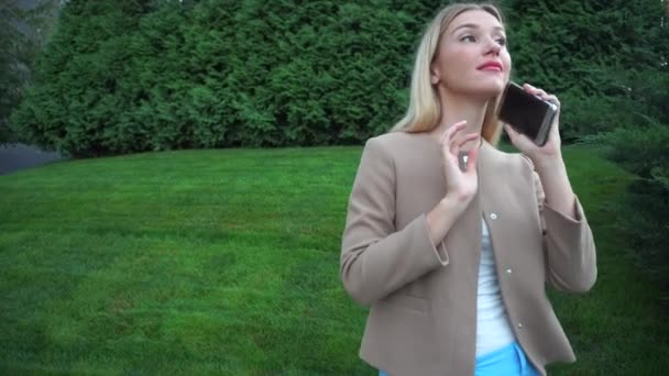 Junge schöne blonde Frau akzeptieren Anruf kommunizieren Gespräch am Telefon grüne Pflanze Hintergrund — Stockvideo