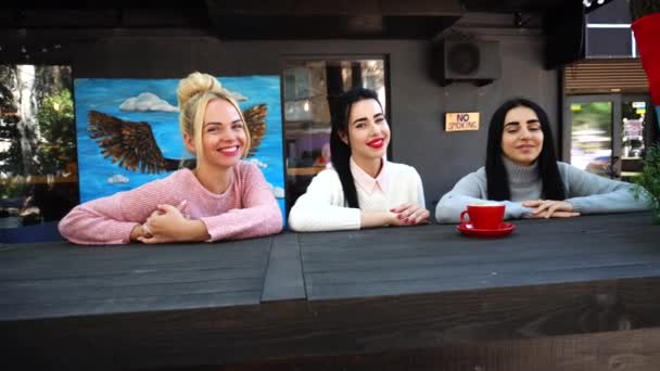 Drie mooie vrouwelijke glimlach in Cafe, praten, vertellen geheimen, eten, koffie drinken. — Stockvideo