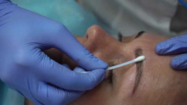 Esteticista hace procedimiento paciente dibuja cejas Mikrobleyding cliente permanente tatuaje, reconstrucción de cejas, pigmentación micro — Vídeos de Stock