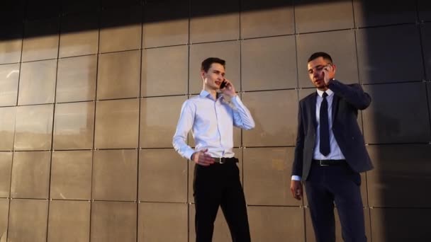 Equipe de negócios chamando falar no telefone perto do escritório central dois homens — Vídeo de Stock
