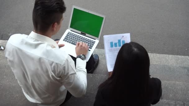 Groen scherm jonge mooie zakenvrouw vrouw en blanke man gebruik documenten, laptop Press toetsenbord zitten op kantoorgebouw trappen — Stockvideo