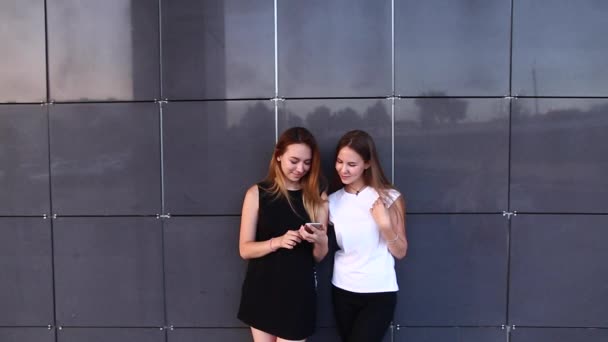 Twee student vrouwelijke vrienden laught kijken naar telefoon — Stockvideo