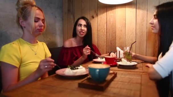Tre vackra kvinnliga leende i Cafe, prata, berätta hemligheter, äta, dricka kaffe. — Stockvideo