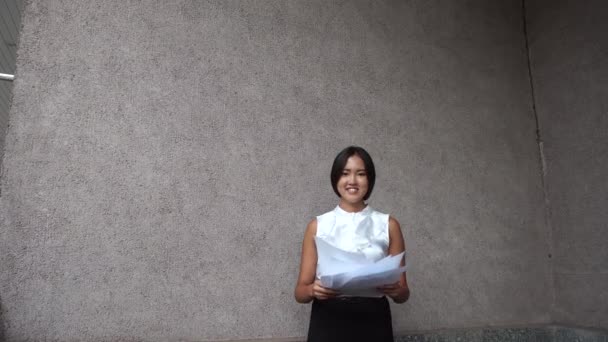Jeune belle femme d'affaires fille portrait attente jeter des documents sur fond immeuble de bureaux en plein air — Video