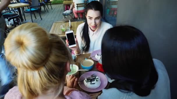 Drie mooie vrouwelijke glimlach in Cafe, praten, vertellen geheimen, eten, koffie drinken. — Stockvideo
