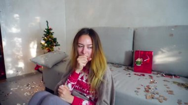 Genç kız portre üzücü hasta soğuk kış virüs ateş Noel ağacı Bokeh Noel arifesi ışıklar yeni yıl konfeti arka plan üzerinde evde