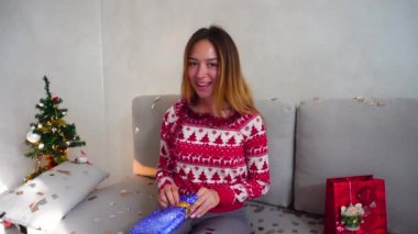 Genç kız portre gülümseme paketi mevcut her Noel ağacı Bokeh Noel arifesi ışıklar yeni yıl konfeti evde