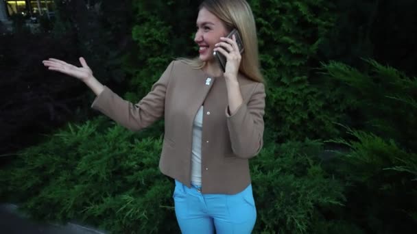 Jonge mooie blonde vrouw praten over de telefoon — Stockvideo