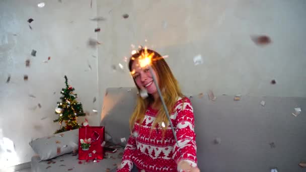 Muchacha joven retrato sonrisa a la cámara, Mira Sparklers, Bengala fuego árbol de Navidad Bokeh Navidad luces año nuevo Confetti — Vídeos de Stock
