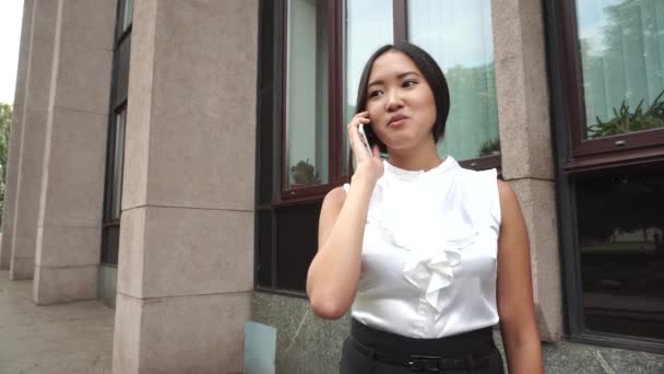 Junge schöne Geschäftsfrau weiblich Mädchen Porträt Gespräch am Telefon halten Dokumente über Hintergrund Bürogebäude im Freien — Stockvideo