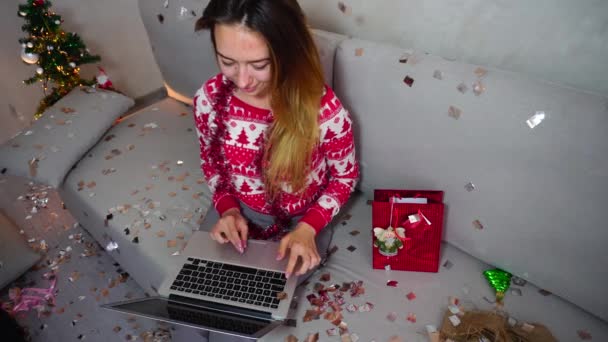 Menina Retrato Sorriso Conversa no laptop inteligente Skype na árvore de Natal Bokeh Xmas Eve Lights Ano Novo Confetti fundo em casa — Vídeo de Stock