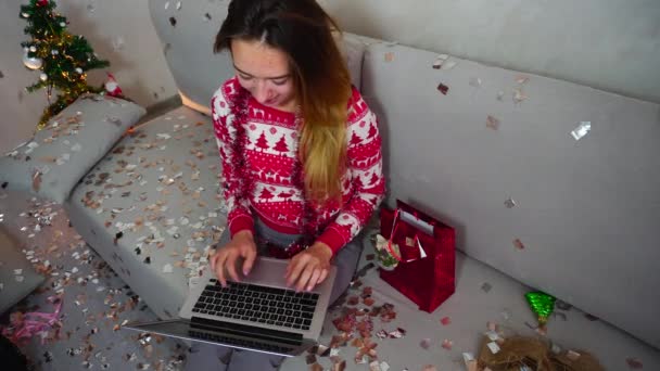 Rapariga Retrato Sorriso Use Teclado no Touchpad Laptop Inteligente na Árvore de Natal Bokeh Xmas Eva Luzes Ano Novo Confetti Fundo em casa — Vídeo de Stock