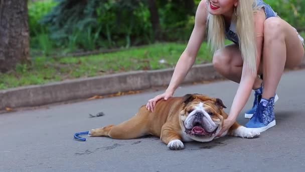 Piękna kobieta gra Walking Buldog amerykański — Wideo stockowe