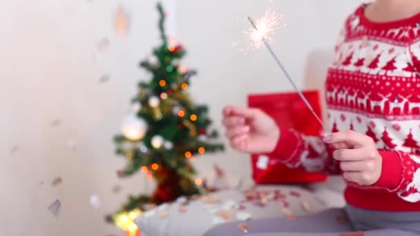 Young Girl Uses Hand Hold Sparklers, Bengal Fire Christmas Tree on Bokeh Xmas Eve Lights New Year Tree Confetti — Wideo stockowe