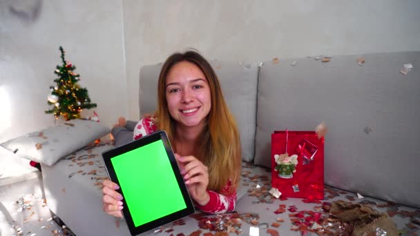 Muchacha joven retrato sonrisa Mostrar punto pantalla verde tableta árbol de Navidad Bokeh Navidad luces año nuevo Confetti en casa — Vídeo de stock