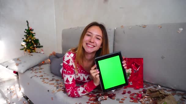 Rapariga Retrato Sorriso Mostrar Ponto Tela Verde Tablet Árvore de Natal Bokeh Xmas Eva Luzes Ano Novo Confetti em casa — Vídeo de Stock