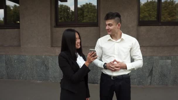 Jeune belle femme d'affaires Femme Montrer le téléphone à Caucasien Homme Portrait Stands sur fond de bureau de plein air — Video
