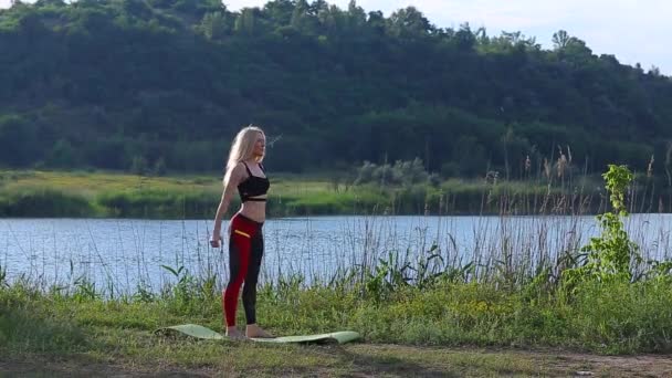 Vrouwelijke atleet squats gewogen arm benen training outdors — Stockvideo