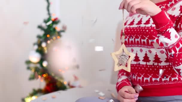 Young Girl Uses Hand Hold Present, Gift Star on Bokeh Xmas Eve Lights New Year Tree Confetti Christmas — 图库视频影像