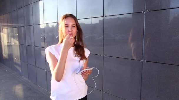 Estudiante chica escuchar música unravels pone en auriculares — Vídeo de stock