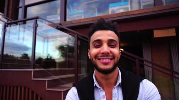 근접 촬영 초상화를 보고 젊은 아랍 사업가의 카메라에 웃 고 배경 유럽 비즈니스 레스토랑 계단 — 비디오